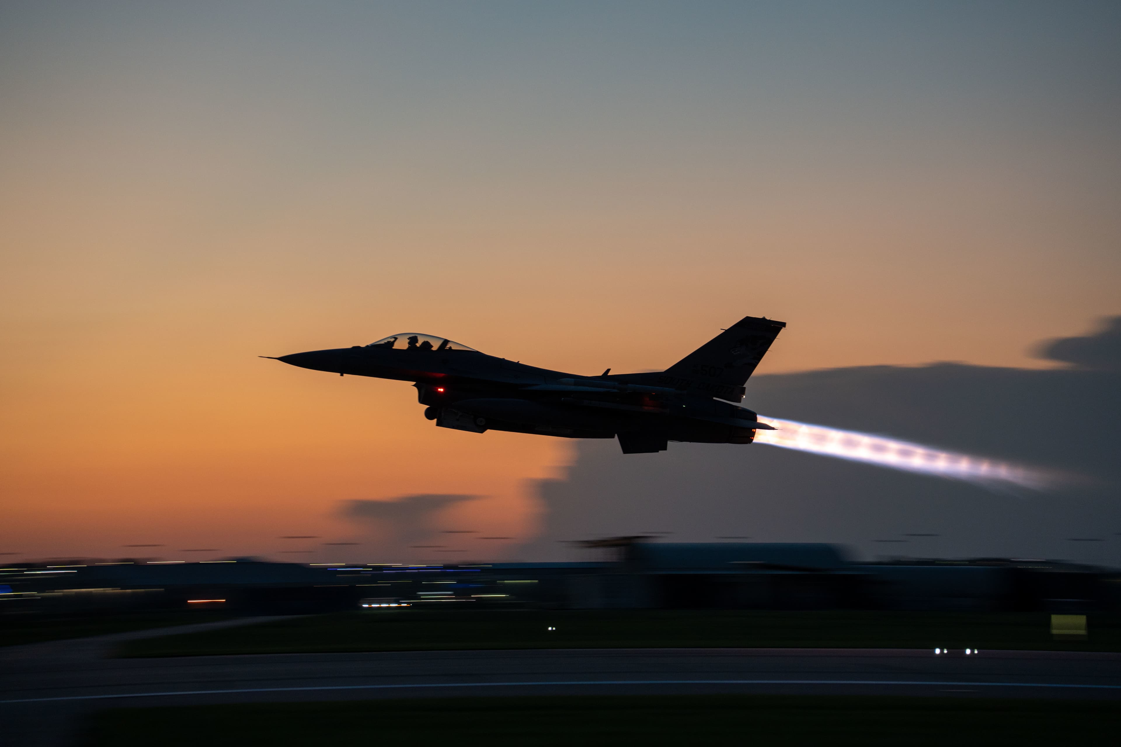 F-16 Fighting Falcon with afterburner engaged - CMMC cybersecurity protecting critical DoD assets in Minnesota